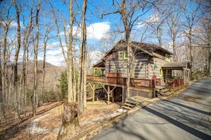 A cabin with a wooden deck, surrounded by trees and a clear sky. - 3 Bedroom 3 Bath Log Cabin just outside of Blowing (Blowing Rock)