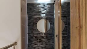 A hallway with a metal railing, a wooden door, and a wall with a geometric pattern. - Luxury Home 2_Starlink 400 Mbit_AC_Jacuzzi_6 People (San Juan del Obispo)