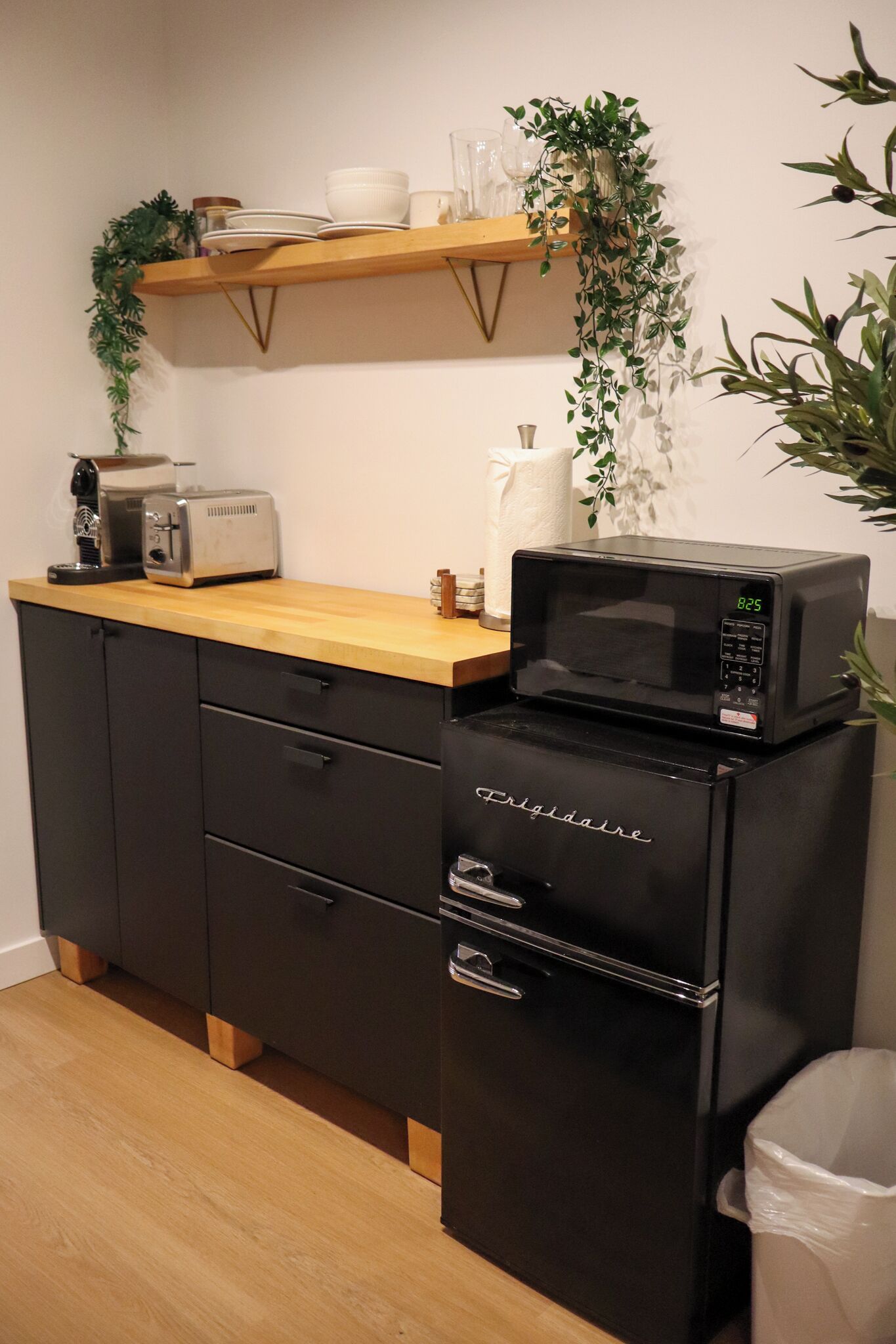Una kitchenette con microondas, tostadora y armarios.