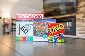 Three board games: Monopoly, UNO, and a game with a puzzle piece design. - Maplecrest Retreat | Firepit • Hot Tub • Game Room (Sevierville)