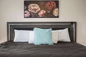 A bed with a dark headboard, two white pillows, and a single light blue pillow. - Maplecrest Retreat | Firepit • Hot Tub • Game Room (Sevierville)