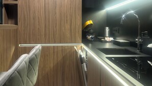 A modern kitchen with wooden cabinetry, a stainless steel sink, and a built-in oven.