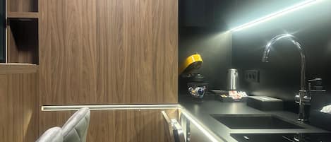 A modern kitchen with wooden cabinetry, a stainless steel sink, and a built-in oven.