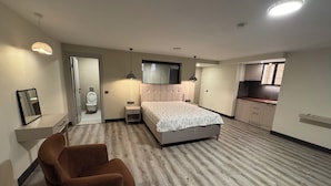 A bedroom with a bed, bedside tables, a chair, a bathroom with a toilet, and a kitchenette. - La Mer Villa Hotels (Marmaris)