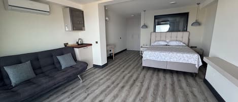 Ein modernes Hotelzimmer mit Sofa, Bett, Schreibtisch und Kleiderschrank.