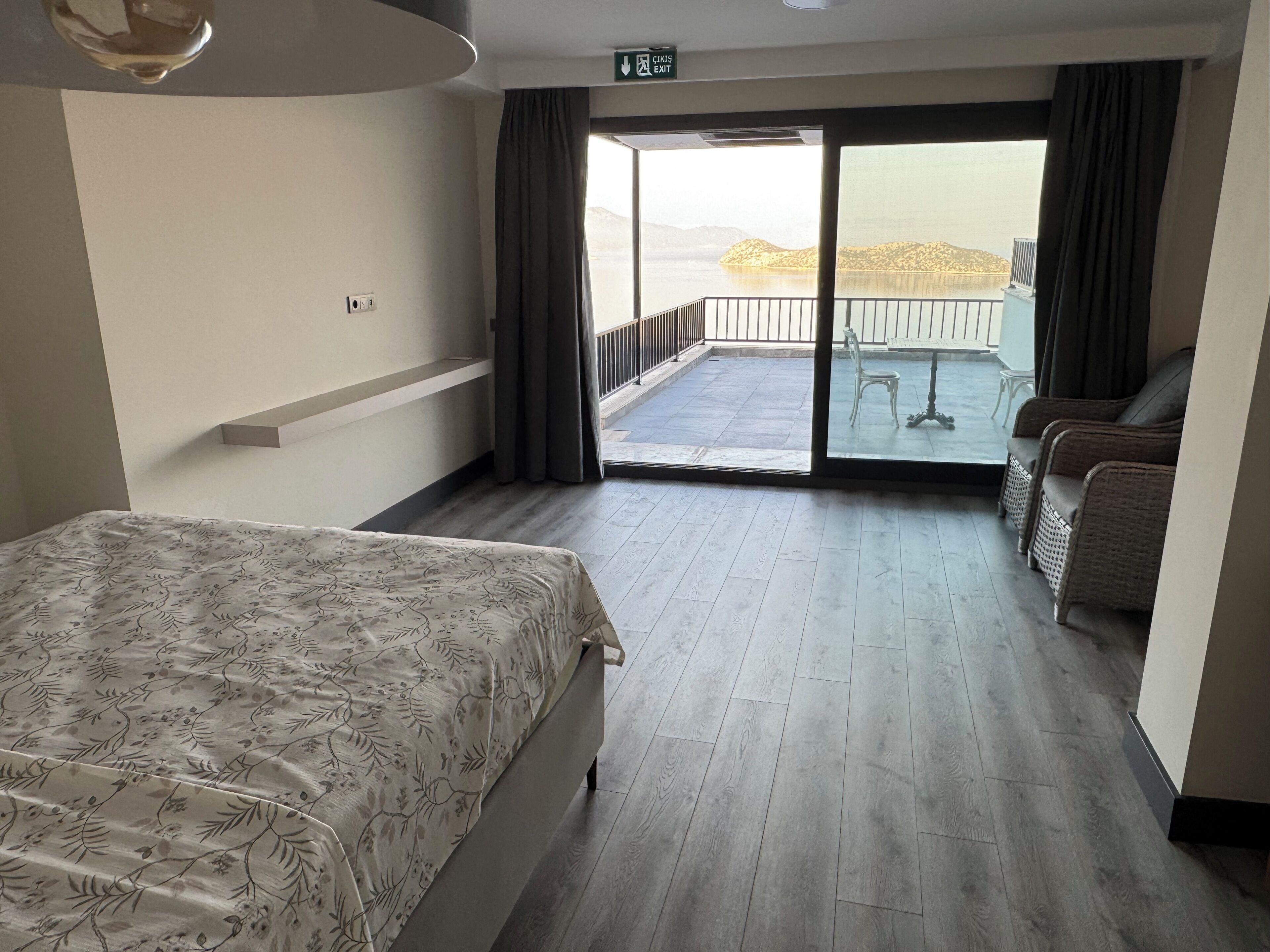 Ein Hotelzimmer mit Bett, einem Balkon und einer Aussicht sowie einer Sitzecke.