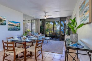 A dining area with a round table, chairs, and a ceiling fan.