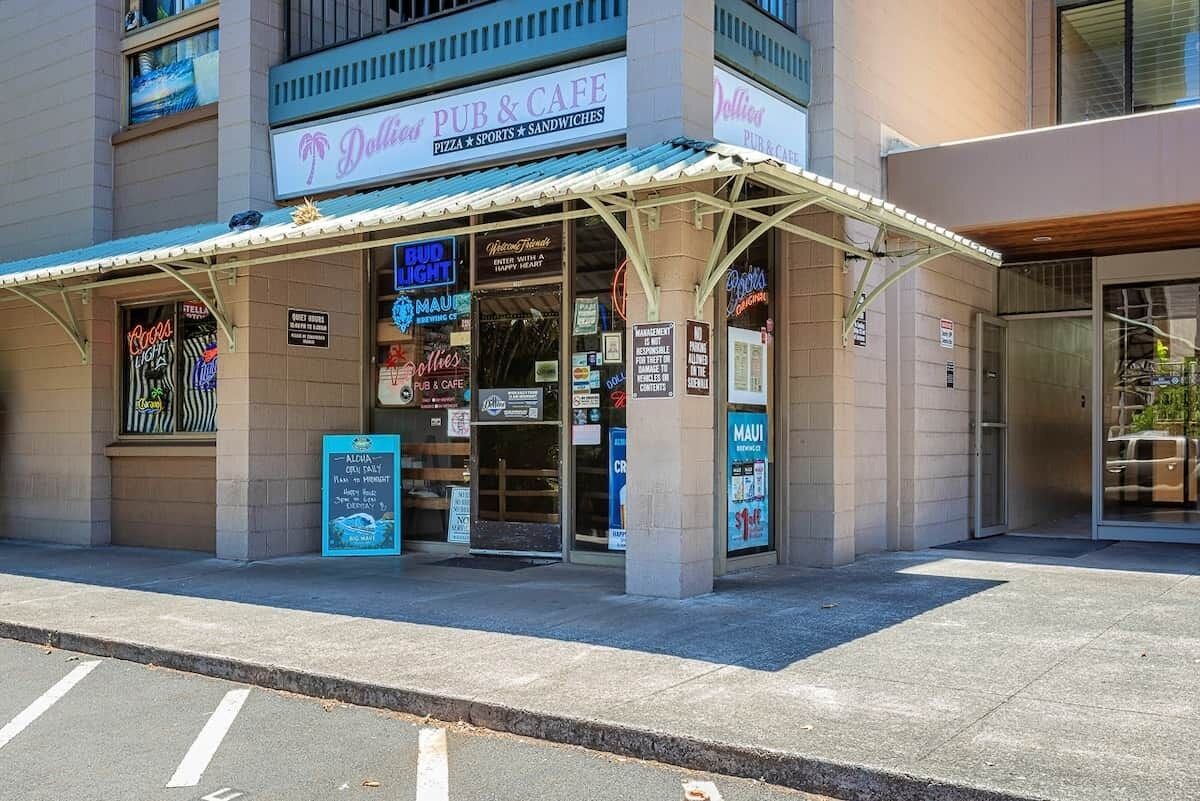 A building with a sign for 'Dollied Pub & Cafe' offering pizza, sports, and sandwiches.