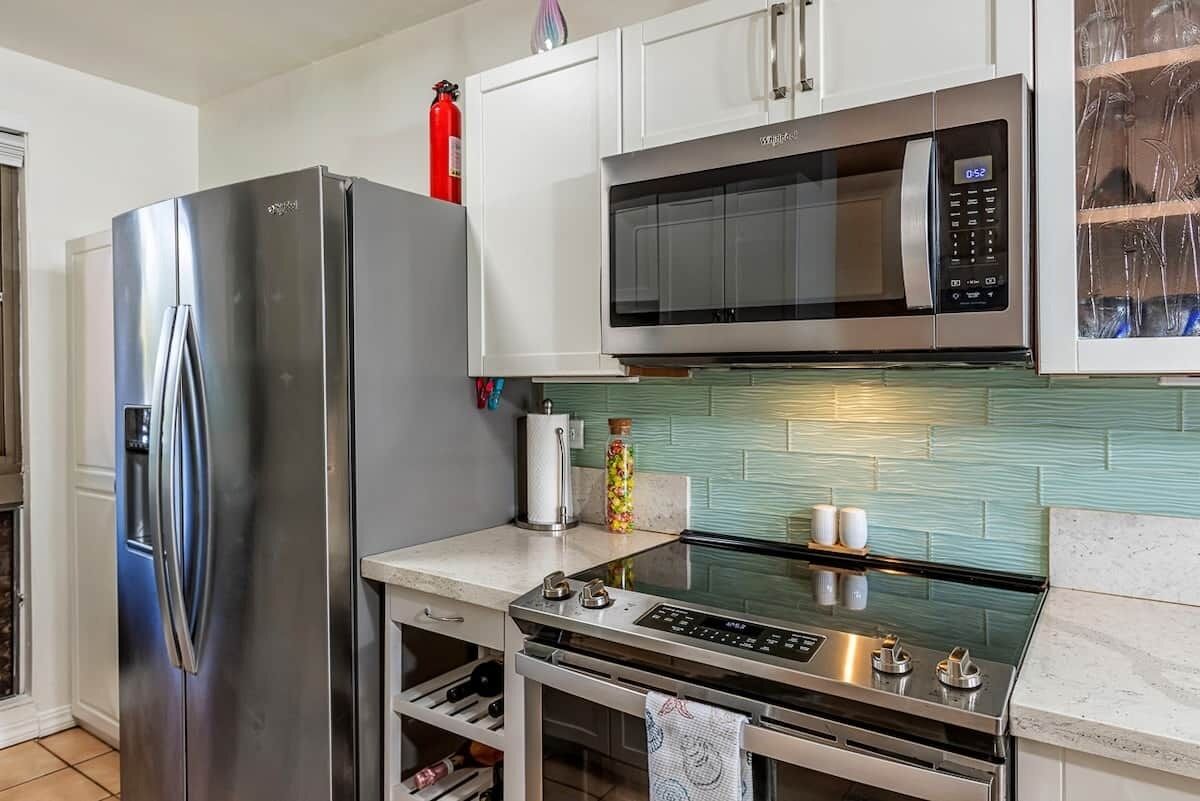 A modern kitchen with stainless steel appliances, including a refrigerator, microwave, and stove.