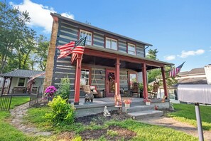 A two-story house with a porch, a mailbox, and a swing set.