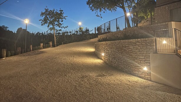 A gravel driveway leading to a stone wall with a tree on the right. - Flumendosa Apartment, Stunning View of the Euganean Hills (Veneto)