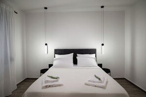 Quarto de hotel moderno com uma cama grande, duas mesas de cabeceira e uma cabeceira.