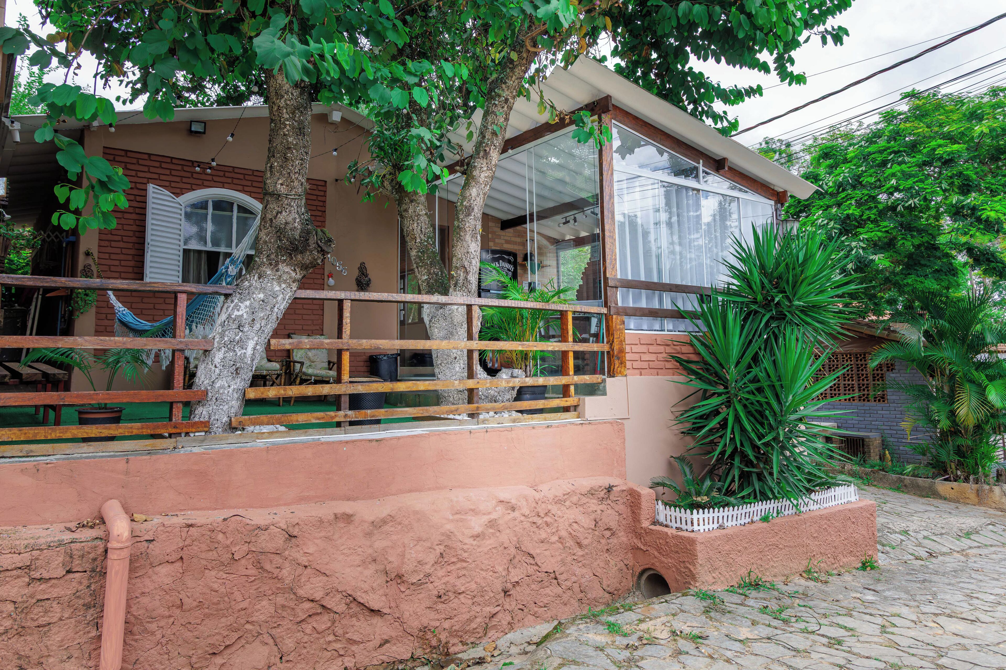 A house with a porch, a hammock, and a potted plant.