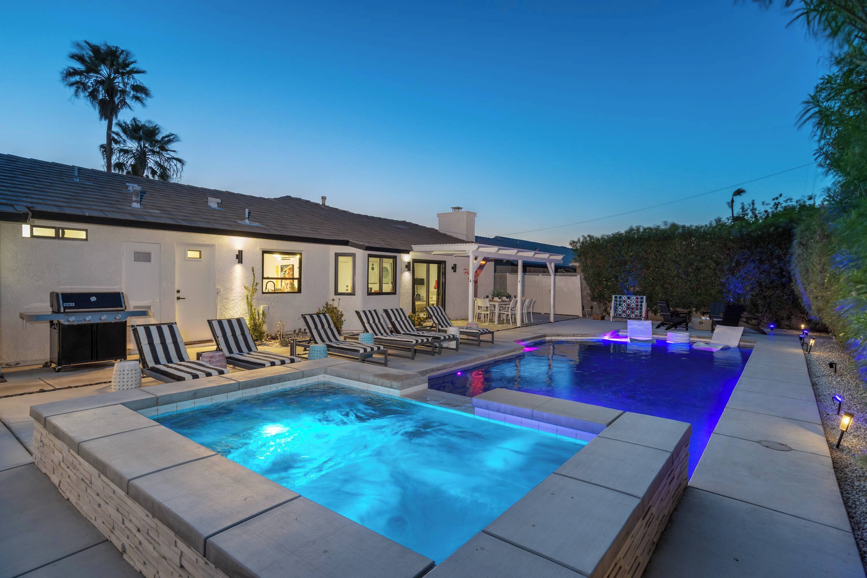 A residential property with a swimming pool, lounge chairs, and a barbecue area.