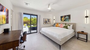 Una habitación de hotel moderna con una cama, escritorio y vistas al exterior.