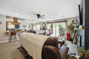 A modern kitchen with a dining area, a ceiling fan, and a view of the outdoors. - Cozy Getaway, an ultimate Tulsa suburb retreat and a backyard oasis. (Tulsa)