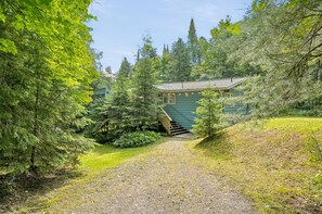 A pathway leading to a green building with a staircase. - Muskoka River Cottage - Kayaks, Firepit, BBQ, Wifi (Bracebridge)