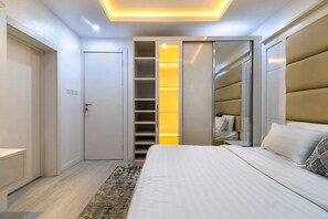 Ein Schlafzimmer mit einem Bett, einem Kleiderschrank und einem Schrank mit gelbem Licht.