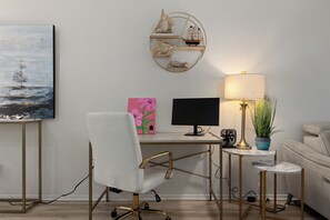 A modern office space with a desk, chair, computer, lamp, and decorative items. - Seas the day! Just a 5 minute walk to the beach! 2bd 2 bath sleeps 8 (South Padre Island)