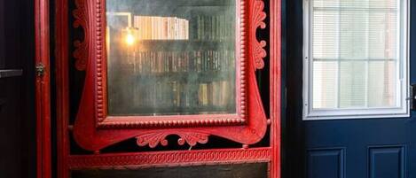 A red ornate wooden bench with a glass panel and a leopard print cushion.