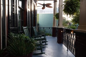 A covered outdoor seating area with chairs and potted plants.