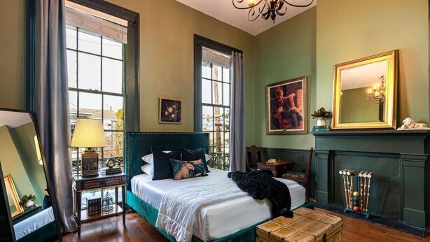 Una habitación con una cama grande, chimenea y una mesa de billar.