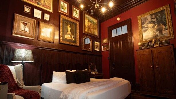 A hotel room with a large bed, a chair, a desk, and a wardrobe. - Marigny Historic 1BD Steps to Jazz & Frenchmen (New Orleans)