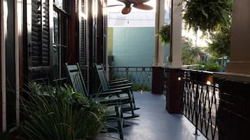A covered outdoor seating area with chairs and potted plants.
