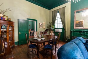 Une salle à manger avec une table en bois, dressée pour quatre personnes, entourée de chaises.