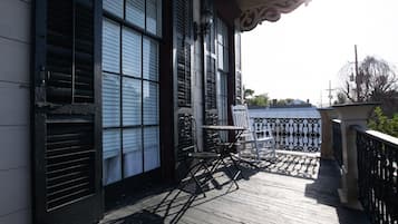 A wooden deck with a table and chairs, overlooking a body of water.