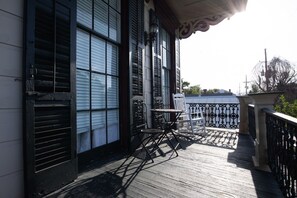 A wooden deck with a table and chairs, overlooking a body of water.