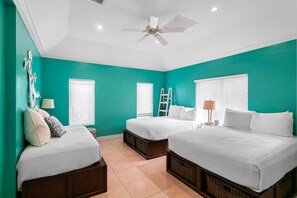 A bedroom with teal walls, two beds, a ceiling fan, and white bedding. - Foxy Lady - Waterfront Luxury Villa sleeps 14 (Exuma)
