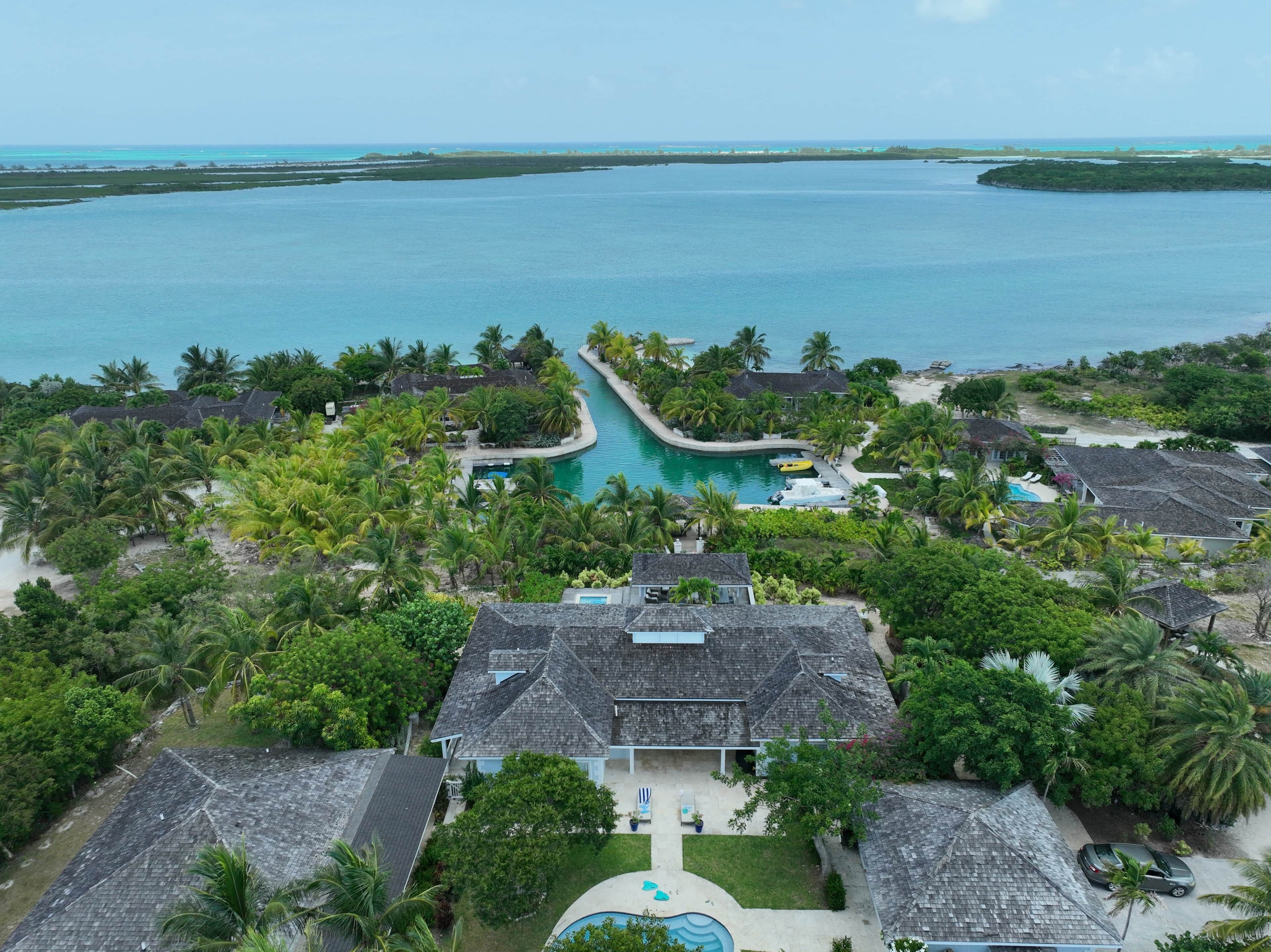 A resort with multiple buildings, a swimming pool, and a view of the ocean.