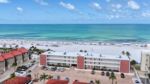 A hotel with a beach view, multiple parking levels, and a clear sky. - A10 - Gulf Breeze Getaway (Siesta Key)