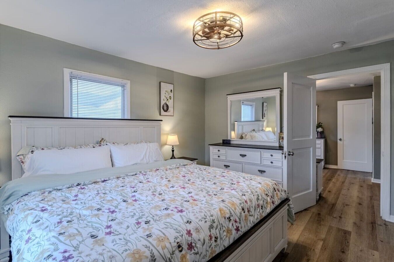 Un dormitorio con cama, cómoda y espejo.
