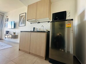 Eine moderne Küche mit Holzschränken, einem Edelstahlkühlschrank und einer gefliesten Spritzschutzwand.