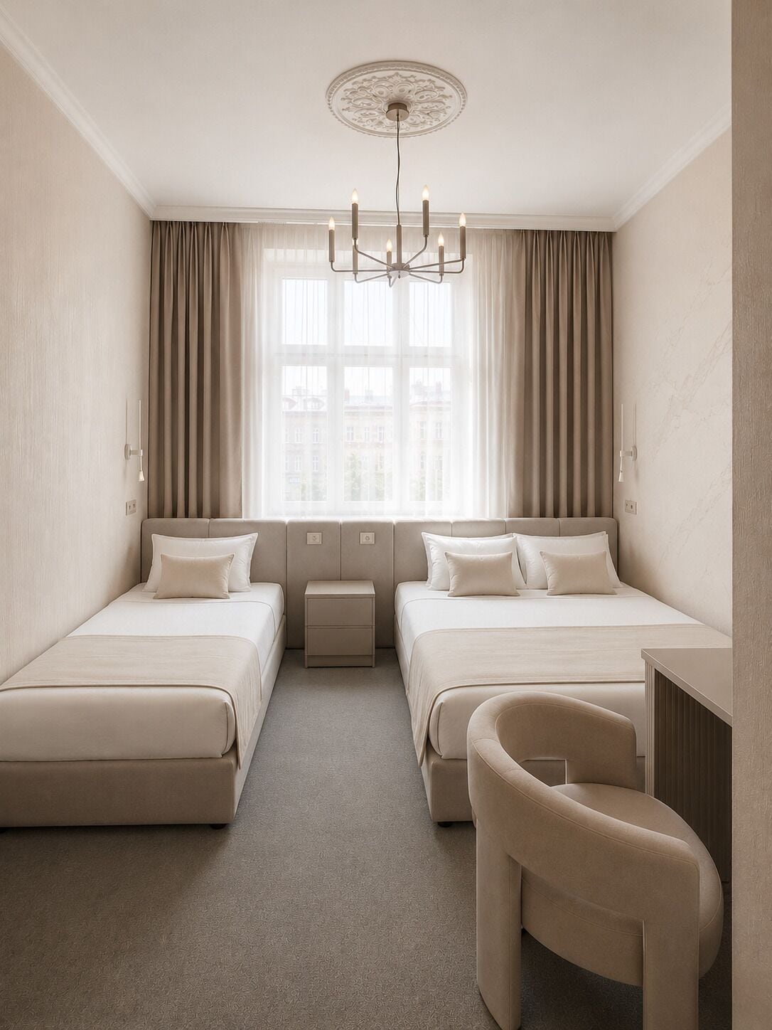 Ein Hotelzimmer mit zwei Betten, einem Schreibtisch, einem Sessel, einem Fenster mit Vorhängen und einer Kristallleuchter.
