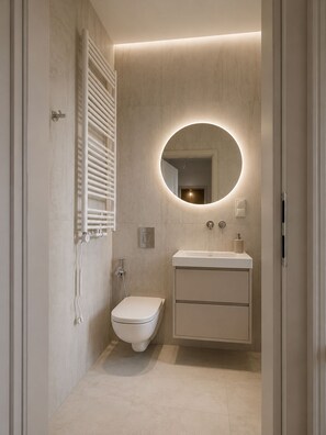 A modern bathroom with a toilet, sink, and mirror. - Kleparski House (Kraków)