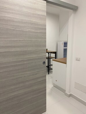 A modern kitchen with white cabinets, a wooden countertop, and a built-in refrigerator. - ShaMic Apartment | Comfort moderno a Milano • M1 Rossa a 350 m (Milano)