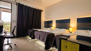 A hotel room with two beds, a desk, and a chair.