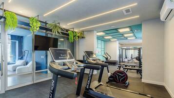 Ein modernes Fitnessstudio mit Laufbändern, Ergometer und Gewichten.