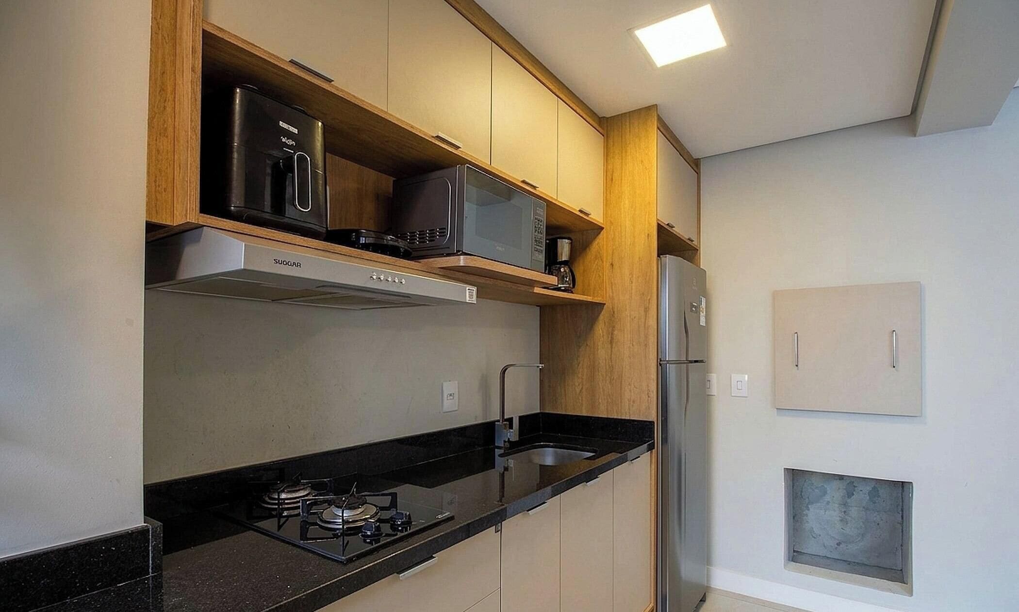 Una cocina moderna con estufa a gas, microondas y refrigerador.