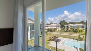 Ein Balkon mit Blick auf ein Schwimmbecken und eine Wohngegend.