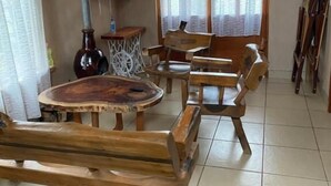 Ein rustikales Interieur mit Holzmöbeln, einem Kamin und einem großen Fenster.