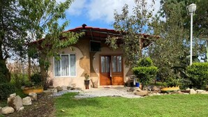 Ein eingeschossiges Haus mit rotem Dach, einer Haustür und einer kleinen Veranda.