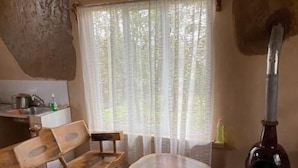 Ein rustikales Interieur mit Holzmöbeln, einem großen Fenster mit Vorhängen und einem Kamin.