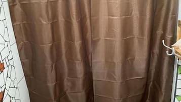 A bathroom with a shower curtain, tiled walls, and a toilet.