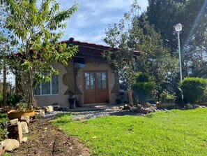A house with a red roof, a front door, and a small porch area. - Cabañas los Abuelos (Zacatlán)