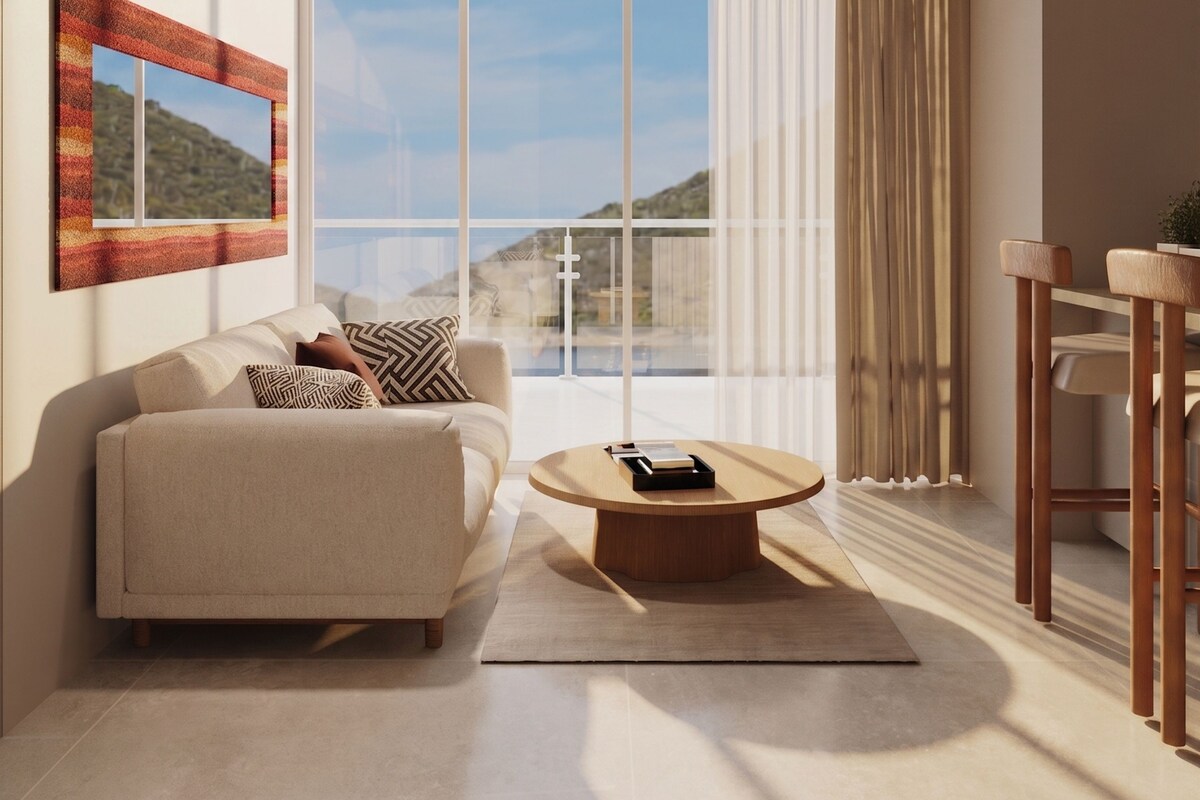 A modern living room with a sofa, a coffee table, and a dining area with a table and chairs.