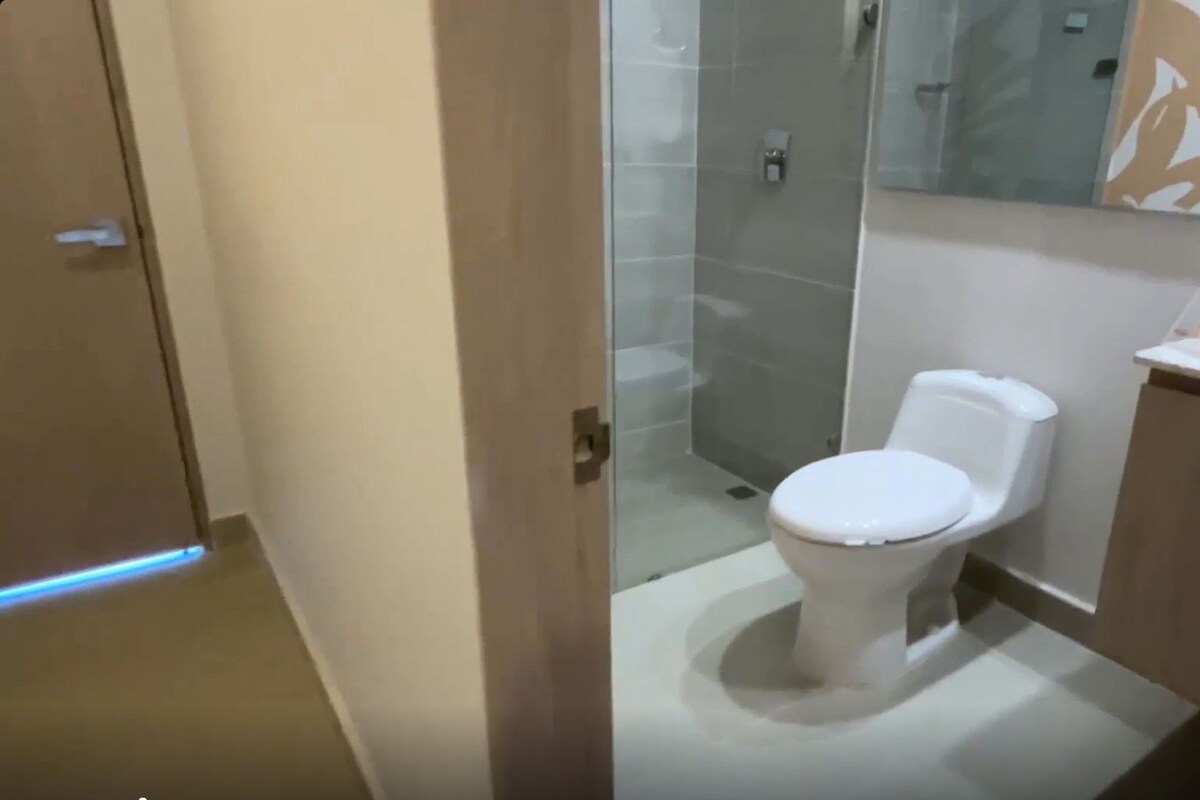 Une salle de bain moderne équipée de toilettes, d’une douche et d’un lavabo.